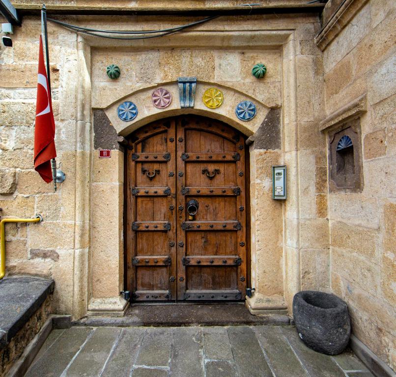 a large wooden door on a building with a flag at Kadievi in Ürgüp