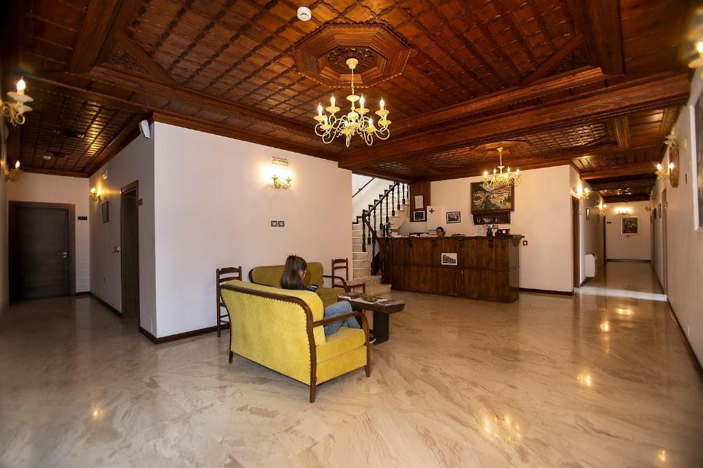 a woman sitting in a yellow chair in a room at Hotel Onufri in Berat