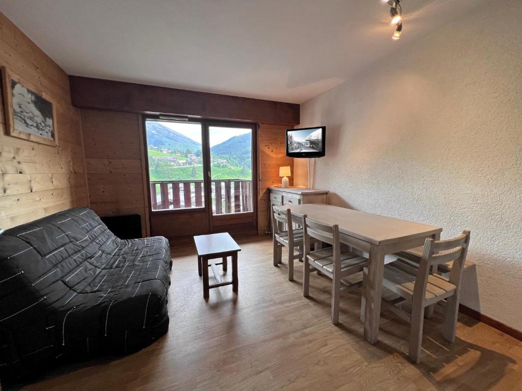 un salon avec une table et un canapé dans l'établissement LA RESIDENCE 2-234 - Proche centre du village avec garage, à La Clusaz