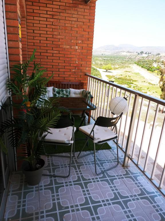 a balcony with two chairs and a bench on it at Apartamento con vistas al mar in Puerto de Mazarrón