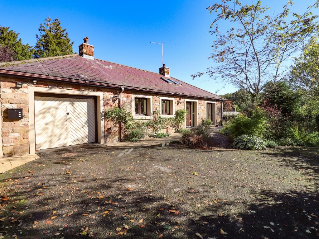 an old brick house with a large garage at Edencroft in Penrith