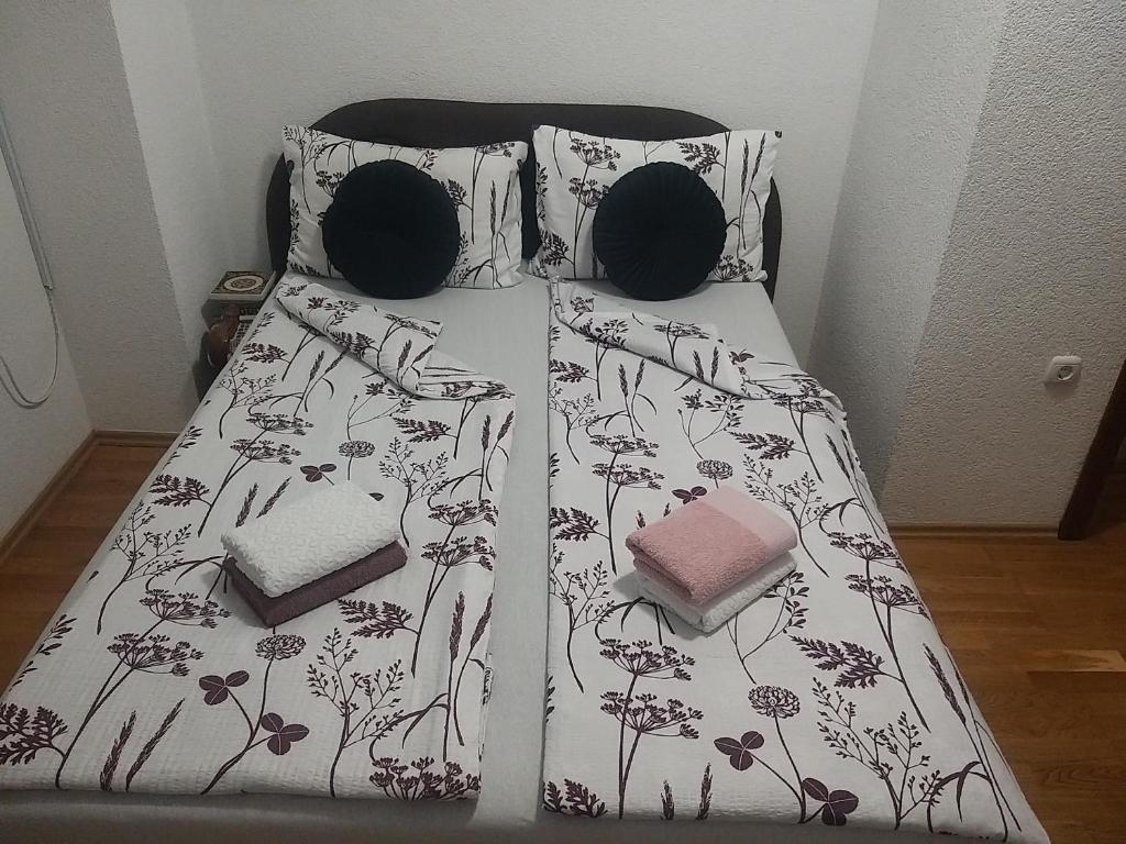 a bed with a black and white comforter and pillows at EMRAH RIVER UNA in Bihać