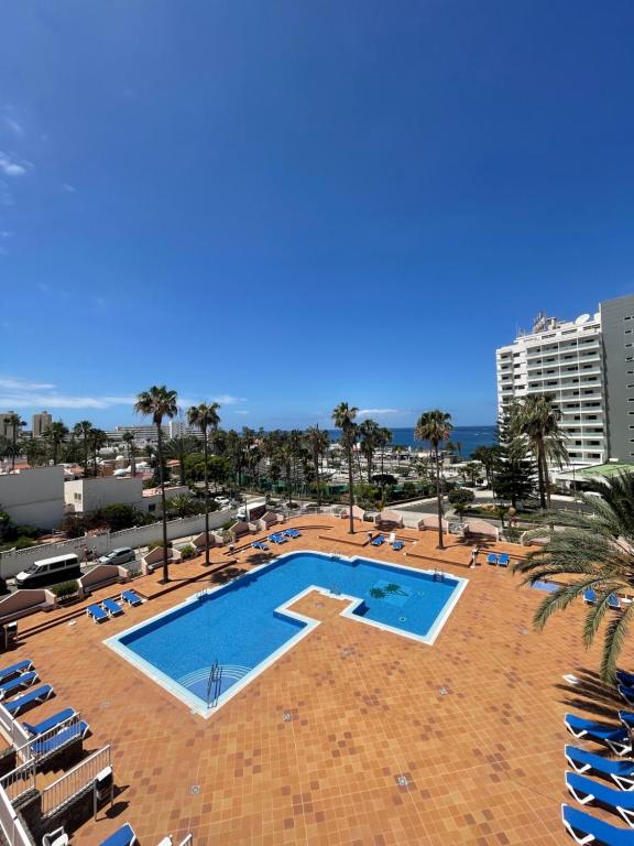 een groot zwembad met stoelen en een gebouw bij Apartment with ocean view, Acapulco,Las Américas in Playa Fañabe