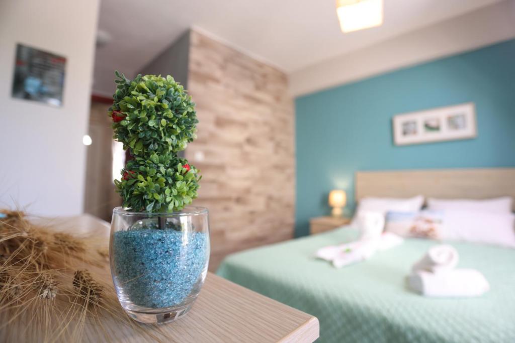 a vase with a plant on a table in a bedroom at Para Thin Alos in Polychrono