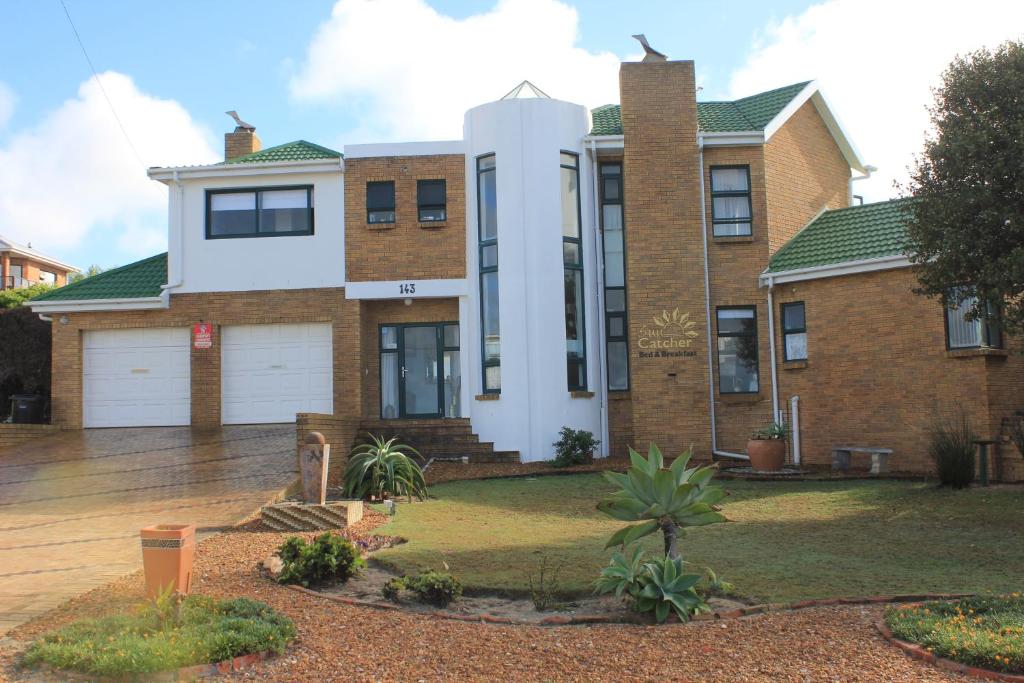 a large brick house with a garage at The Sun Catcher Bed & Breakfast in Struisbaai