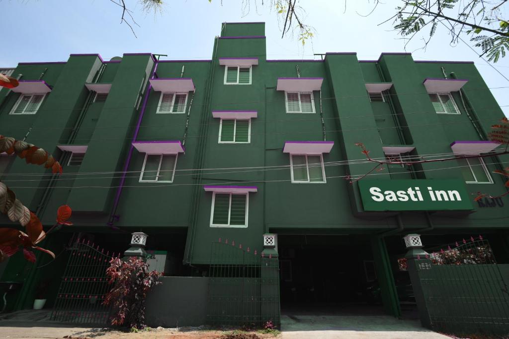 un bâtiment vert avec un panneau indiquant l'auberge est dans l'établissement FabHotel Sasti Inn, à Chennai