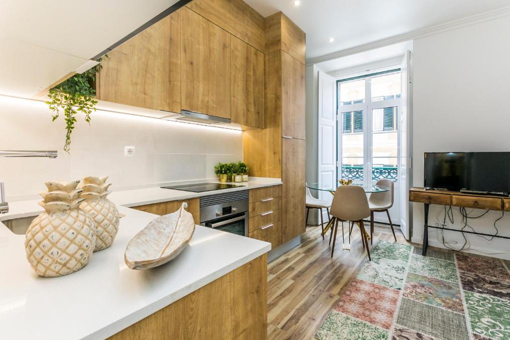 uma cozinha com armários de madeira e uma mesa com televisão em São José by SpotOn Apartments em Lisboa