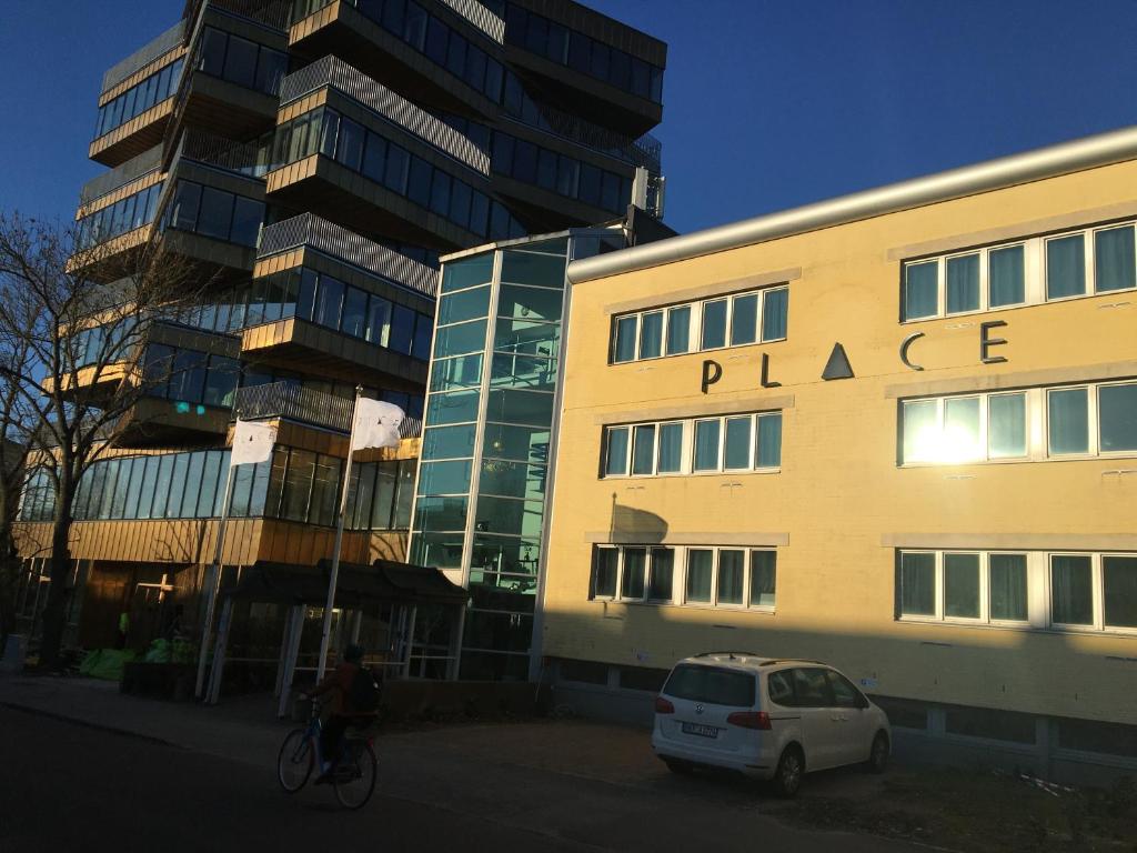 un homme faisant du vélo devant un bâtiment dans l'établissement Place Lund, à Lund