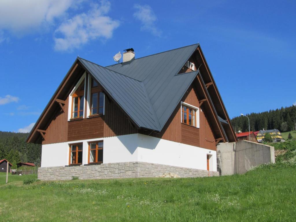 una casa con techo negro en una colina en Berger Pec Privat, en Pec pod Sněžkou