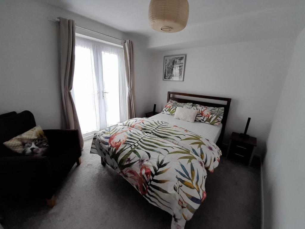 a bedroom with a bed and a window at City centre apartment with south facing patio close to the harbour in Plymouth