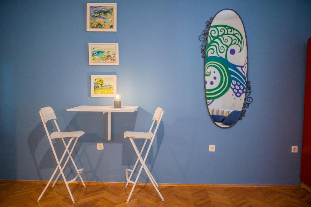 a surfboard on a blue wall with a table and chairs at Apartment Sole Macula in Split