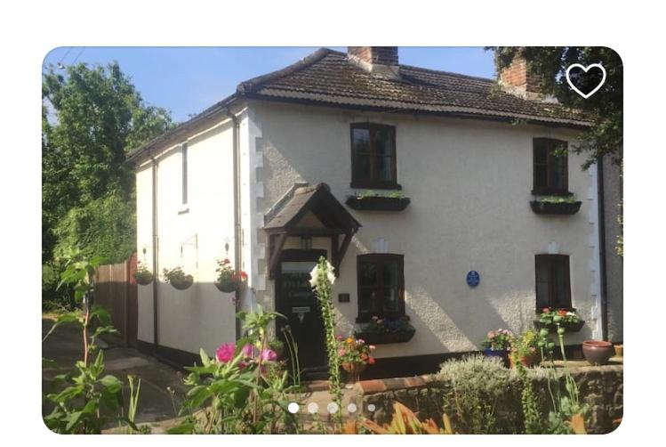 a white house with flowers in front of it at Cricketers Cottage B&B in Kent