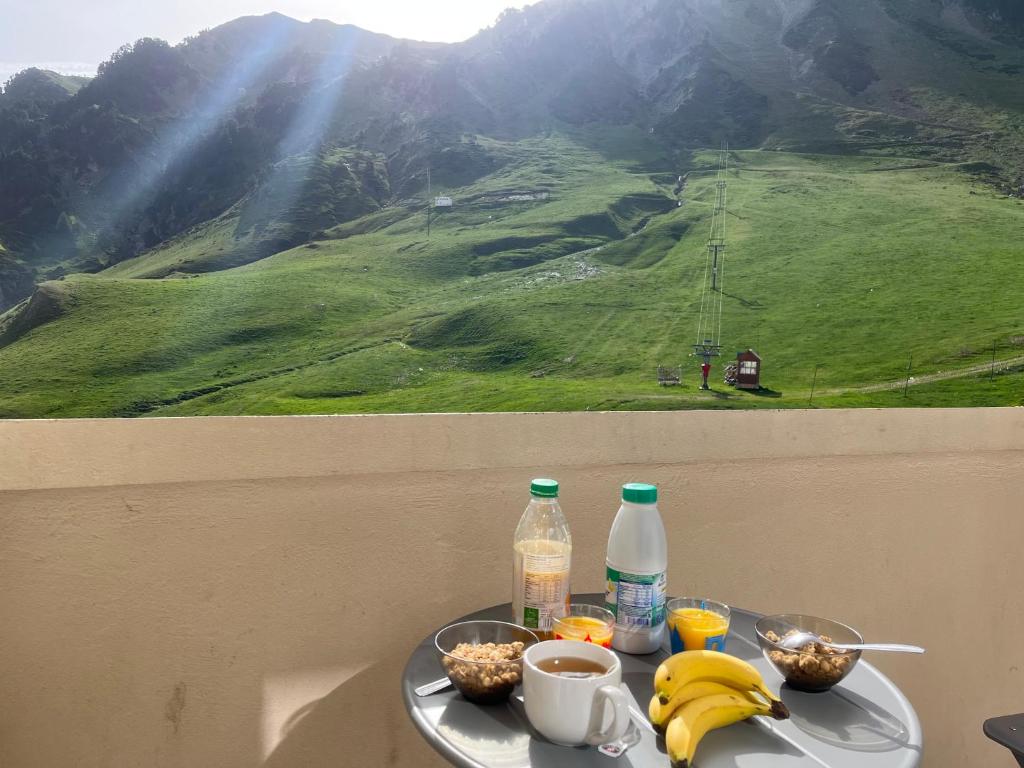 uma mesa com um prato de comida com bananas e bebidas em Appt chaleureux 2 - 4 personnes au pied des pistes - draps et linges de toilette non fournis - ménage non inclus em La Mongie