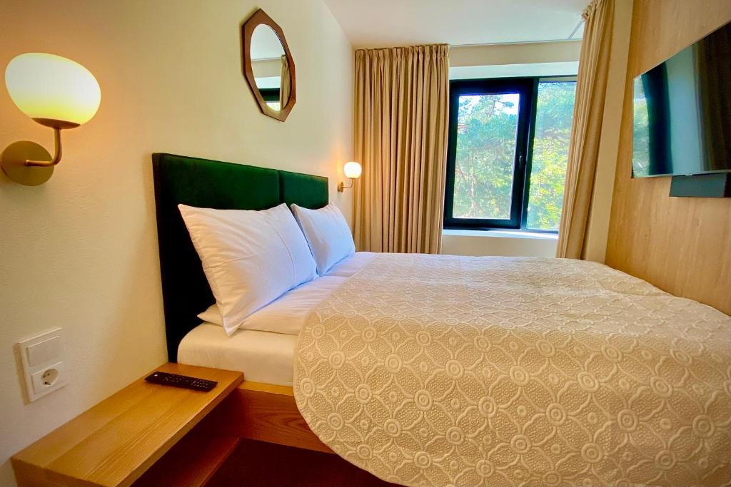 um quarto de hotel com uma cama e uma janela em SIRENA em Palanga
