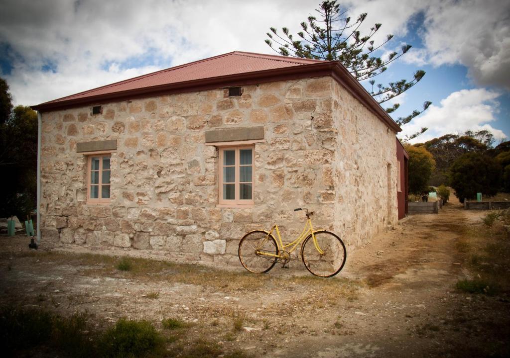a yellow bike parked in front of a stone building at Norfolk Lodge - Dhilba Guuranda-Innes National Park in Inneston