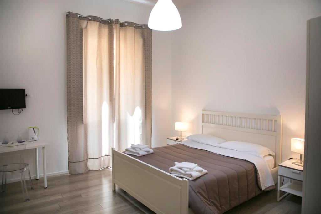 ein Schlafzimmer mit einem großen Bett und einem Fenster in der Unterkunft B&B Barone Sieri Pepoli in Trapani
