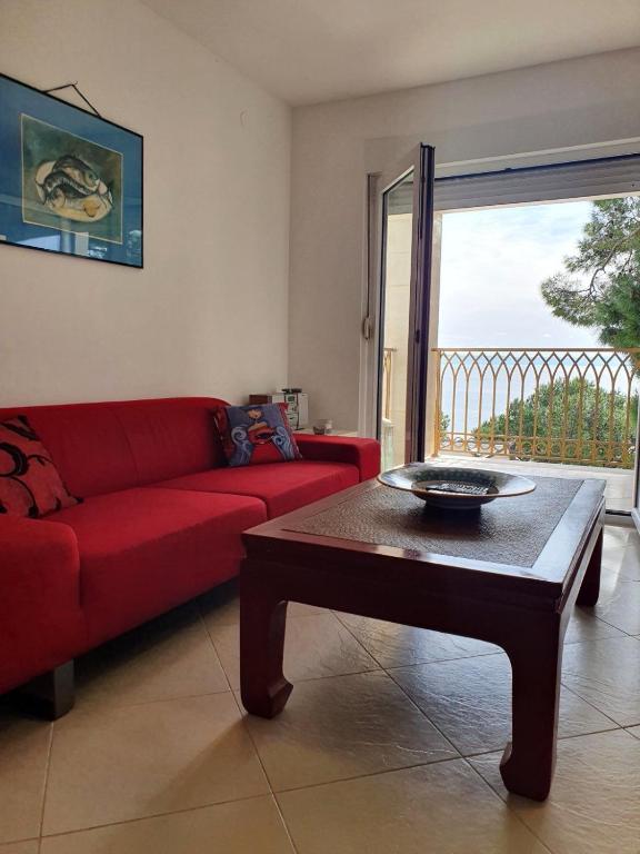 a living room with a red couch and a coffee table at Inas Place in Baška Voda