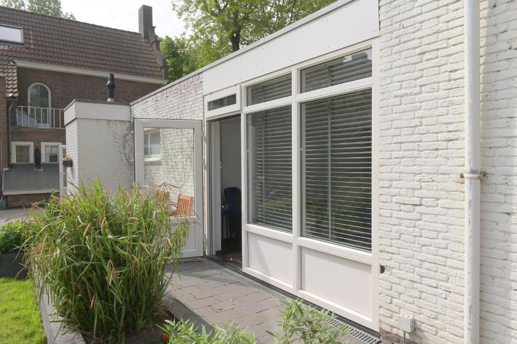 a sliding glass door on a white brick building at AaBenB appartement in Tilburg
