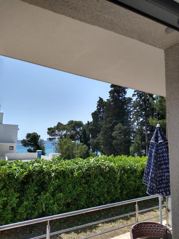 un asciugamano appeso a una ringhiera di fronte a una siepe di Apartments Villa Vetma a Kaštela (Castelli)