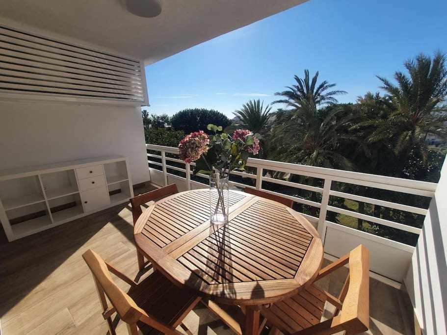 a wooden table with a vase of flowers on a balcony at Eurosol sunny beach apartment in Torremolinos