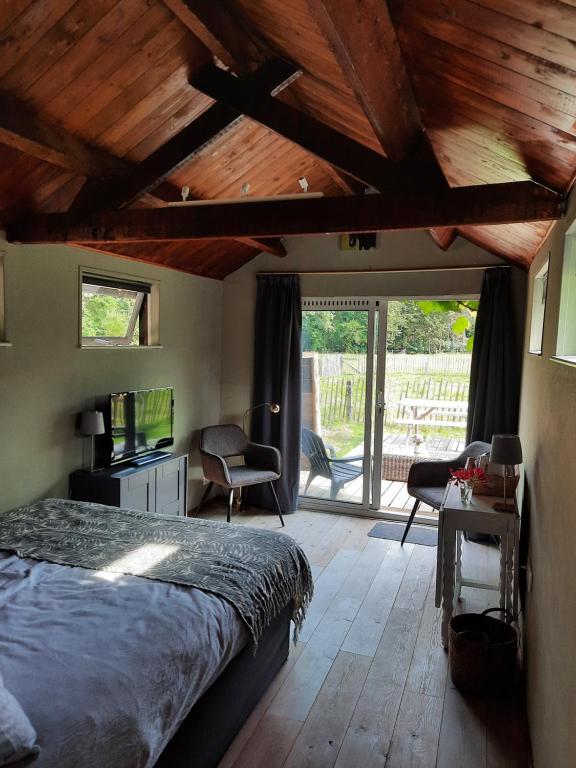 um quarto com uma cama e um tecto de madeira em Eikelhof em Berkel-Enschot