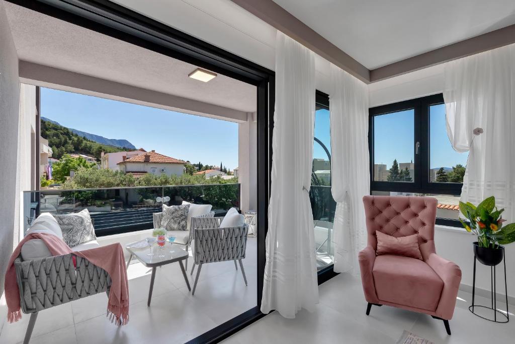 a living room with a large window and a table and chairs at Villa Bomada in Tučepi