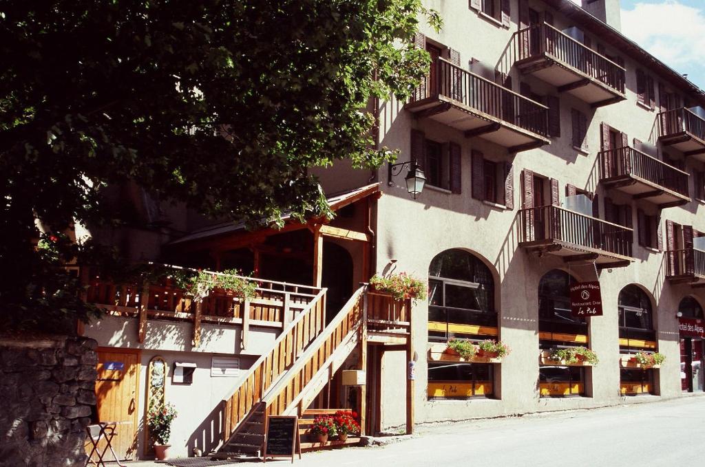 un edificio con balcones y escaleras en una calle en HOTEL DES ALPES - SKIERS LODGE en La Grave