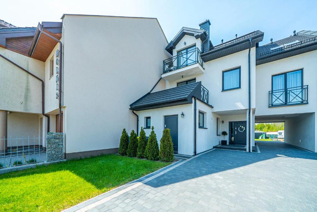 a large white house with a driveway at U motyli in Jastarnia