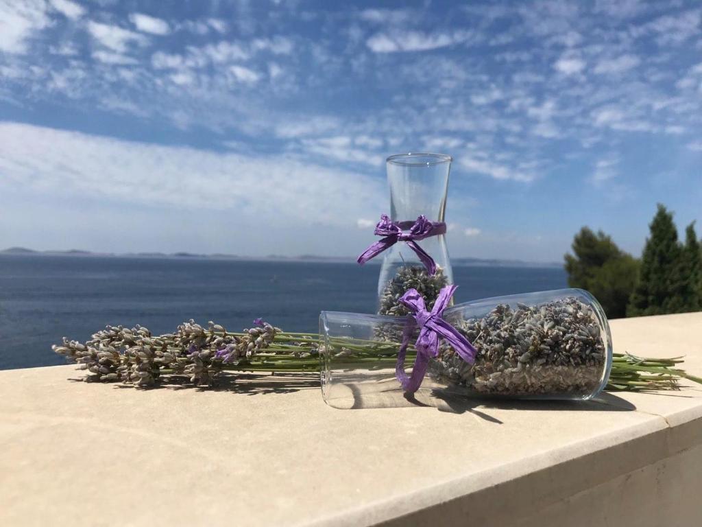 a couple of glass vases with flowers on a ledge at Apartmani Silvano in Murter