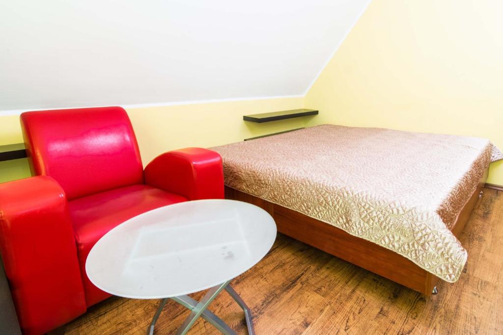 ヴロツワフにあるRed Apartmentのベッドルーム1室(ベッド1台、赤い椅子付)