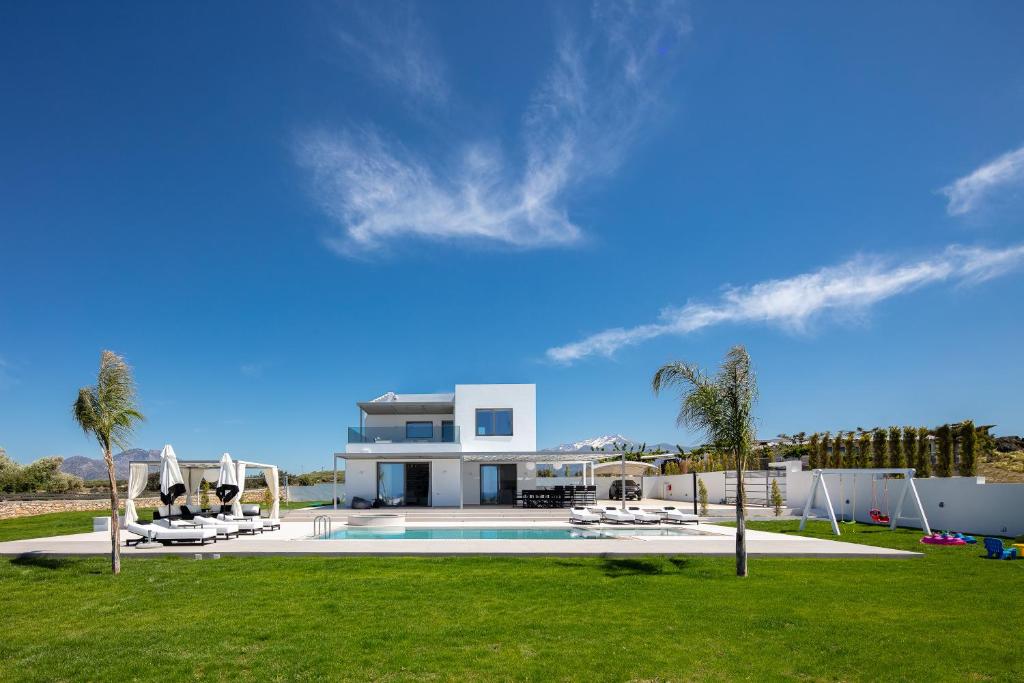 a large house with a swimming pool and palm trees at Alma Villa, 2000m2 Luxury Living, by ThinkVilla in Angeliana