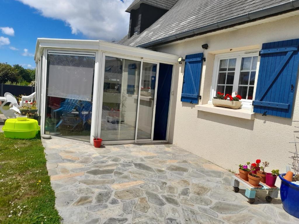 une terrasse avec volets bleus sur une maison dans l'établissement Maison Entre Terre et Mer, à Primelin