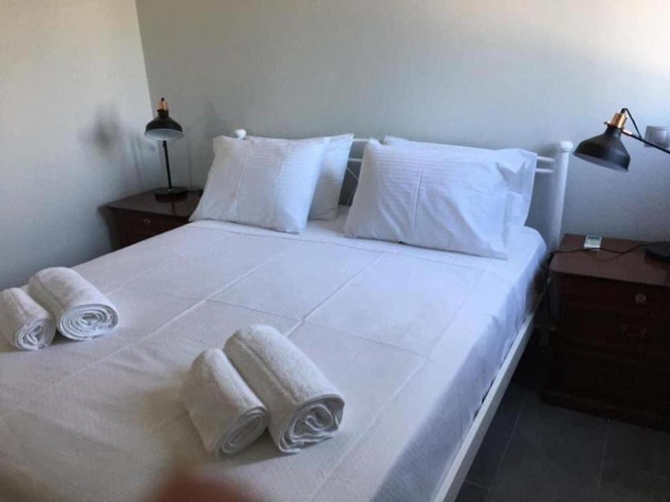 - une chambre avec un lit blanc et des serviettes dans l'établissement Viva s apartment, à Metaxáta