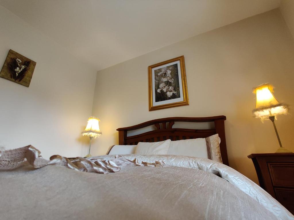 a bedroom with a large white bed with two lamps at 'Senán' Luxury Double Room in Foxford