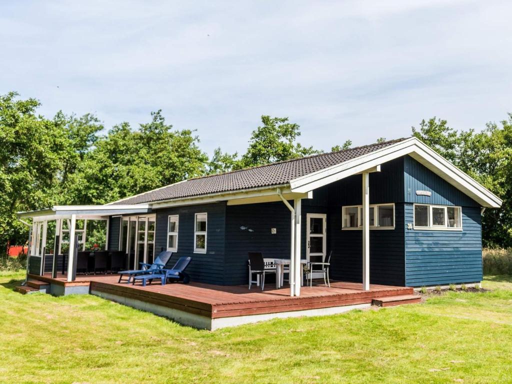 a blue house with a deck and chairs at Tranquil Oasis in Rindby in Fanø