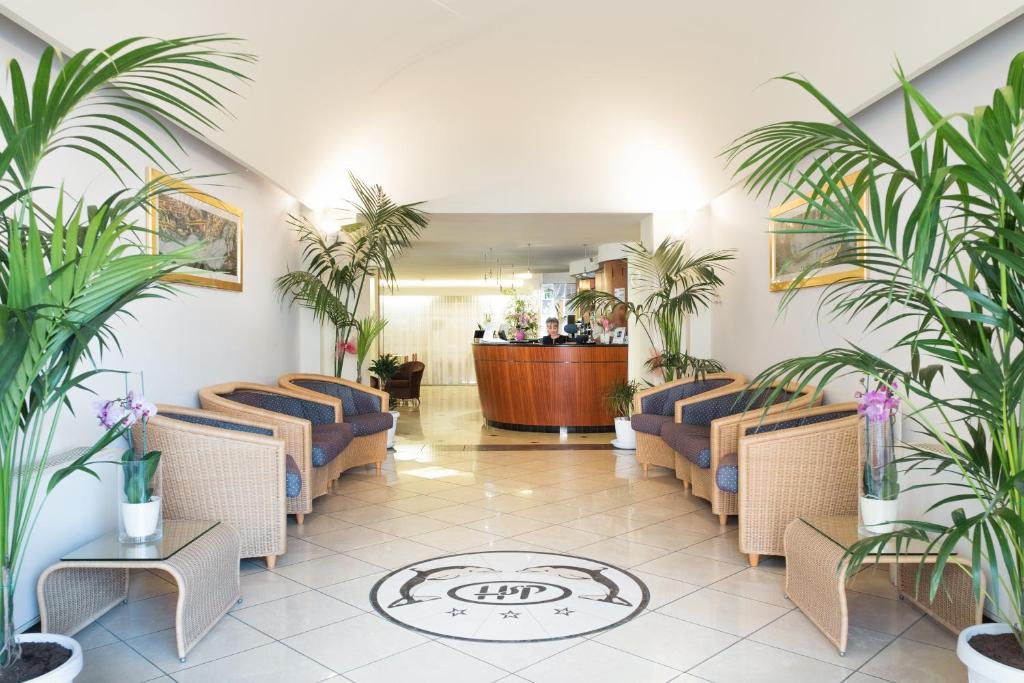 a waiting room with blue chairs and plants at Hotel St Pierre in Rimini