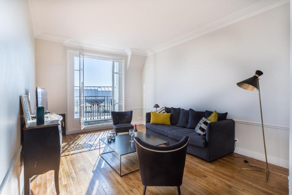 a living room with a couch and a table at GuestReady - Designer Apartment - Eiffel Tower View! in Paris