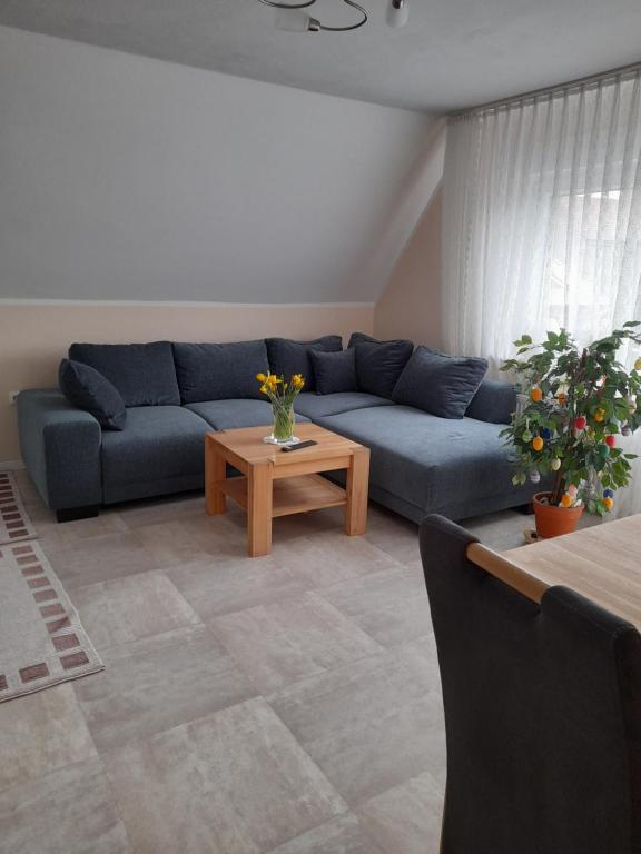 sala de estar con sofá azul y mesa en Ferienwohnung Pham en Hage