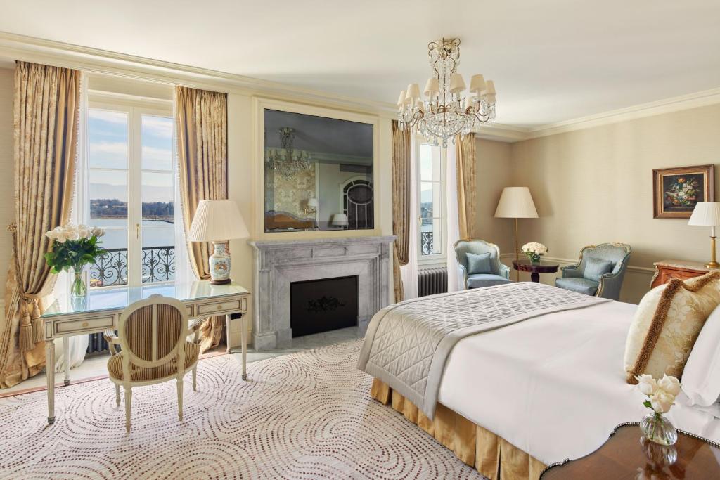 a bedroom with a bed and a desk and a fireplace at Beau-Rivage Genève in Geneva