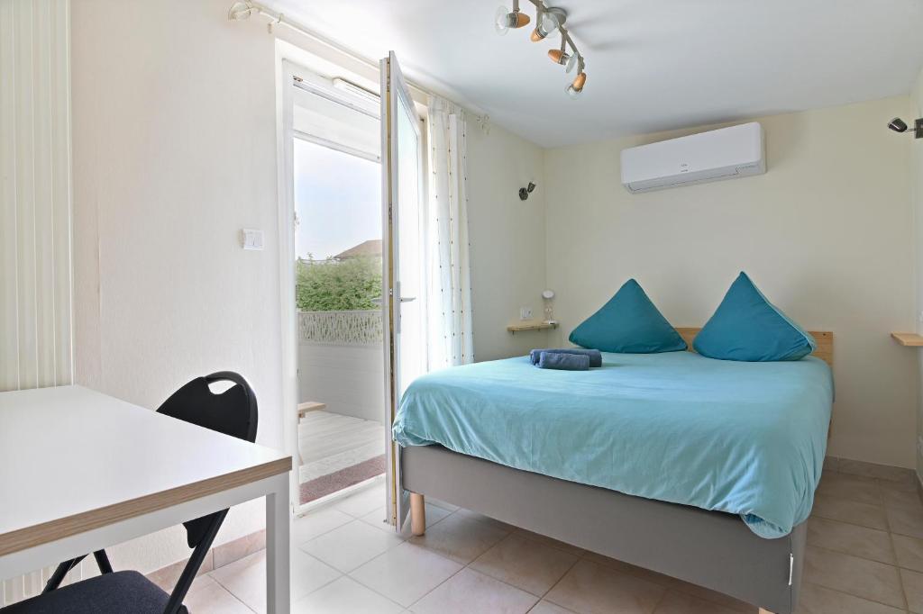 a bedroom with a bed and a desk and a window at La Petite Maison Blanzy in Blanzy