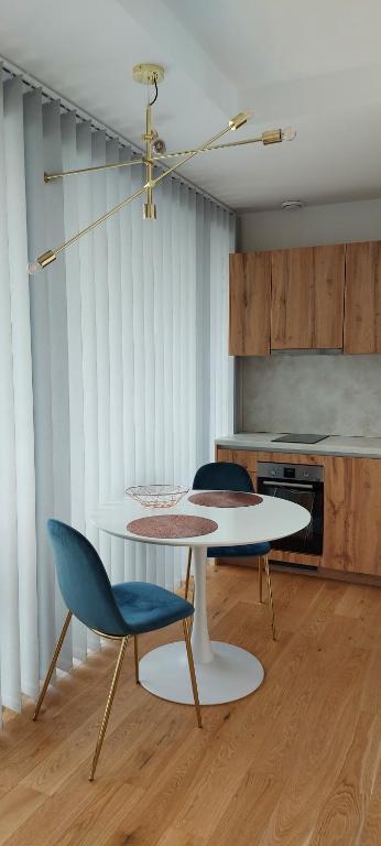 - une cuisine avec une table et deux chaises dans une pièce dans l'établissement Ringi Rannakivi Residents, à Pärnu
