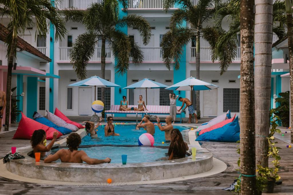 a group of children playing in a pool at a hotel at Mad Monkey Kuta Lombok in Kuta Lombok