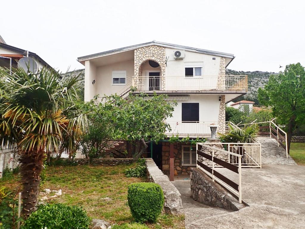 スタリグラードにあるApartments Darijaのヤシの木が目の前に広がる白い家