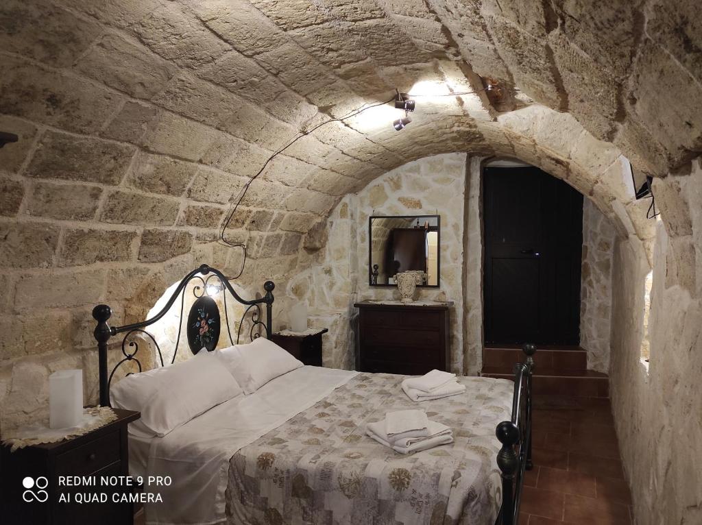 una camera con un letto in una parete in pietra di Il Tufo D'amare appartamento affitti brevi a Rutigliano