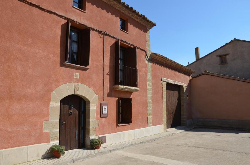 un edificio de ladrillo rojo con puerta y balcón en Casa Rural El Cartero, en Santa Lecina