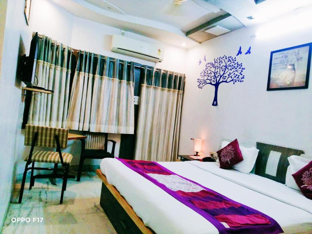 ein Schlafzimmer mit einem Bett und einem Baum an der Wand in der Unterkunft Homestayinn in Ahmedabad