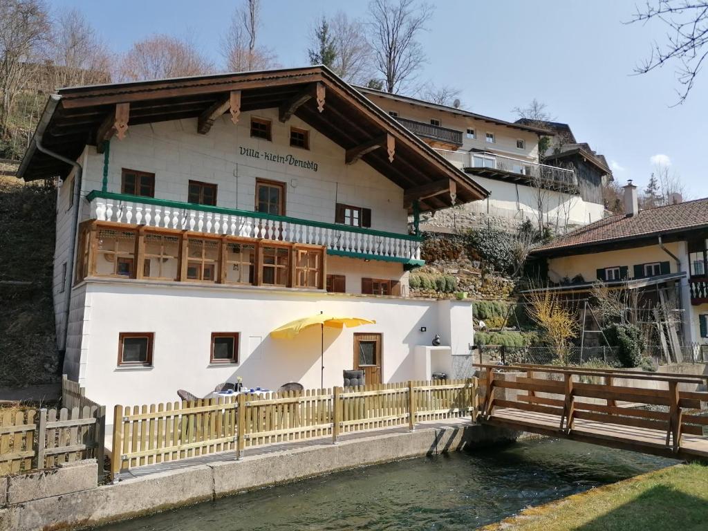 a building with an umbrella next to a body of water at Ferienhaus Villa klein Venedig in Siegsdorf