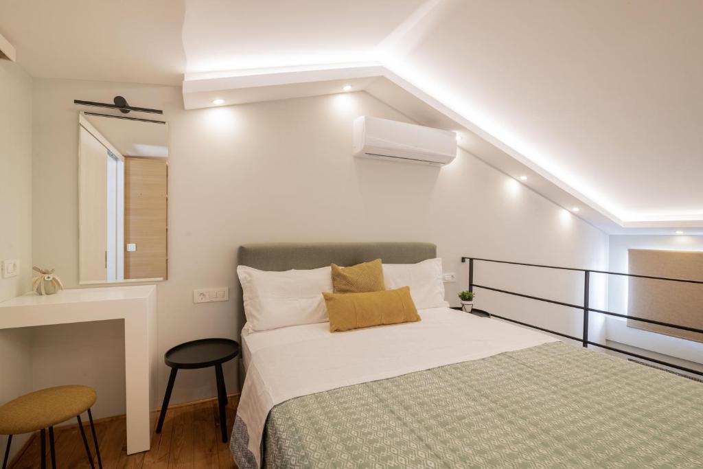 ein kleines Schlafzimmer mit einem Bett und einem Fenster in der Unterkunft Cosy & elegant loft suite in the city center in Zakynthos