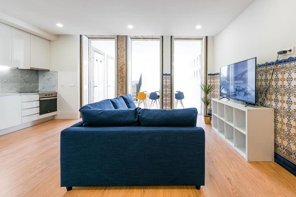 un salon avec un canapé bleu et une télévision dans l'établissement GuestReady - Back to Road to Greenhouse, à Porto