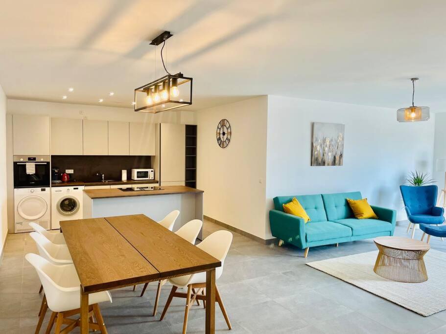 ein Wohnzimmer mit einem Tisch und einem blauen Sofa in der Unterkunft Brand New 2 bedrooms with Parking and Terrace - 142-96 in Luxemburg (Stadt)